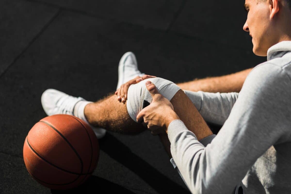 basketball-player-applying-bandage-knee-1200x800.jpg